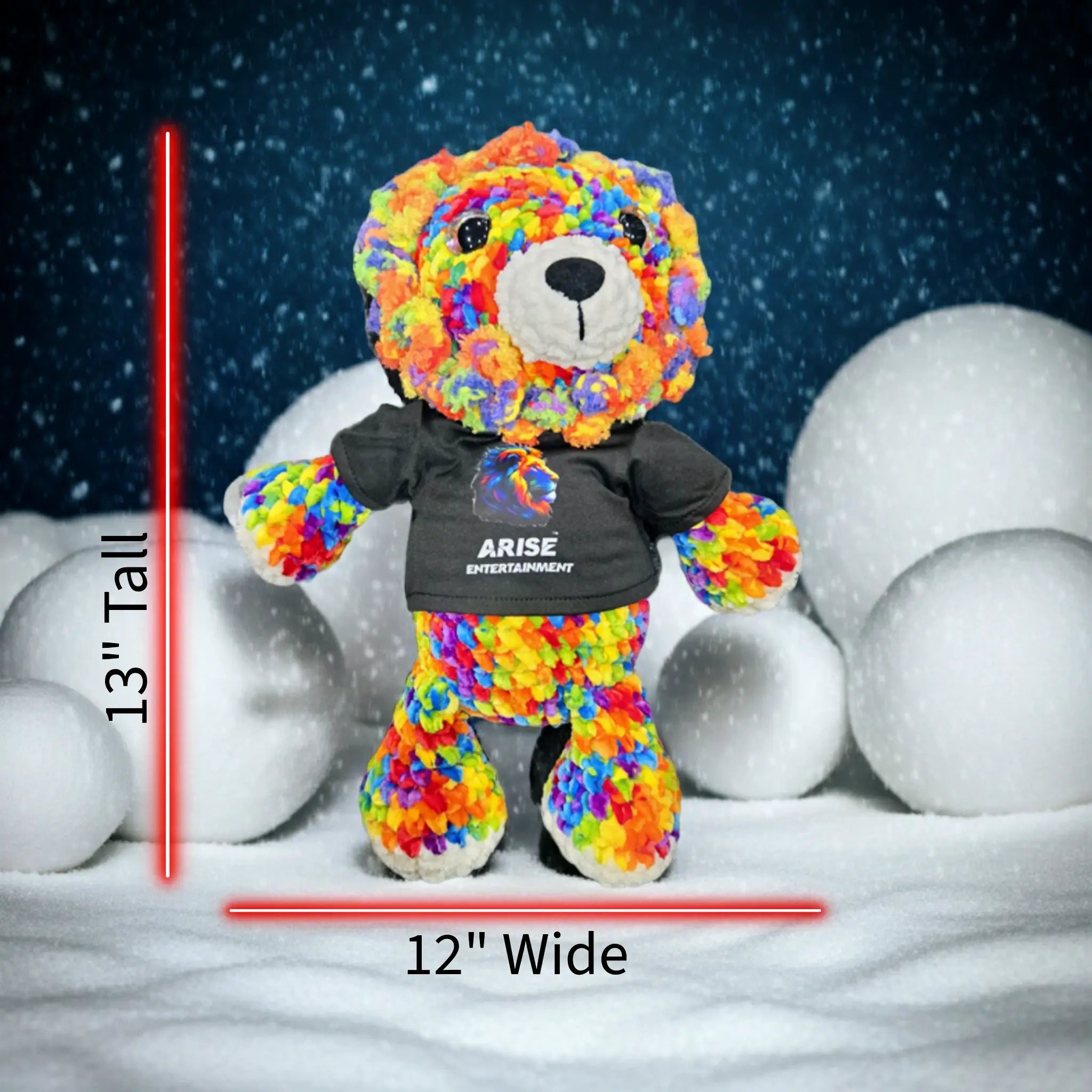 Colorful teddy bear with a black shirt labeled 'Arise Entertainment' on a snowy background